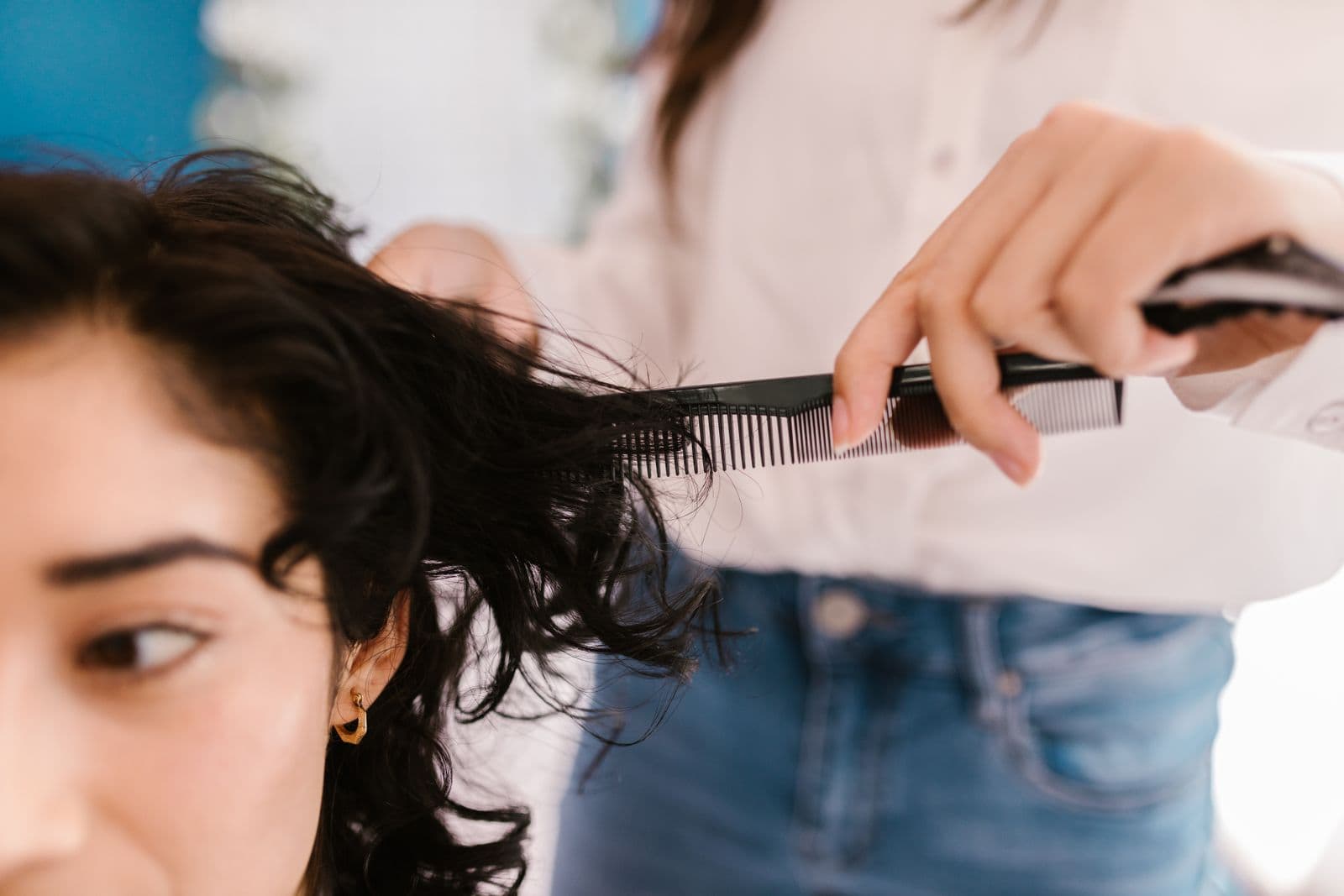 Professional hairstylist styling a clients hair at the salon