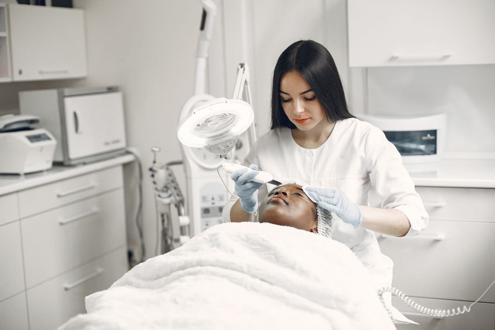 Relaxing facial spa treatment with esthetician caring for a clients skin