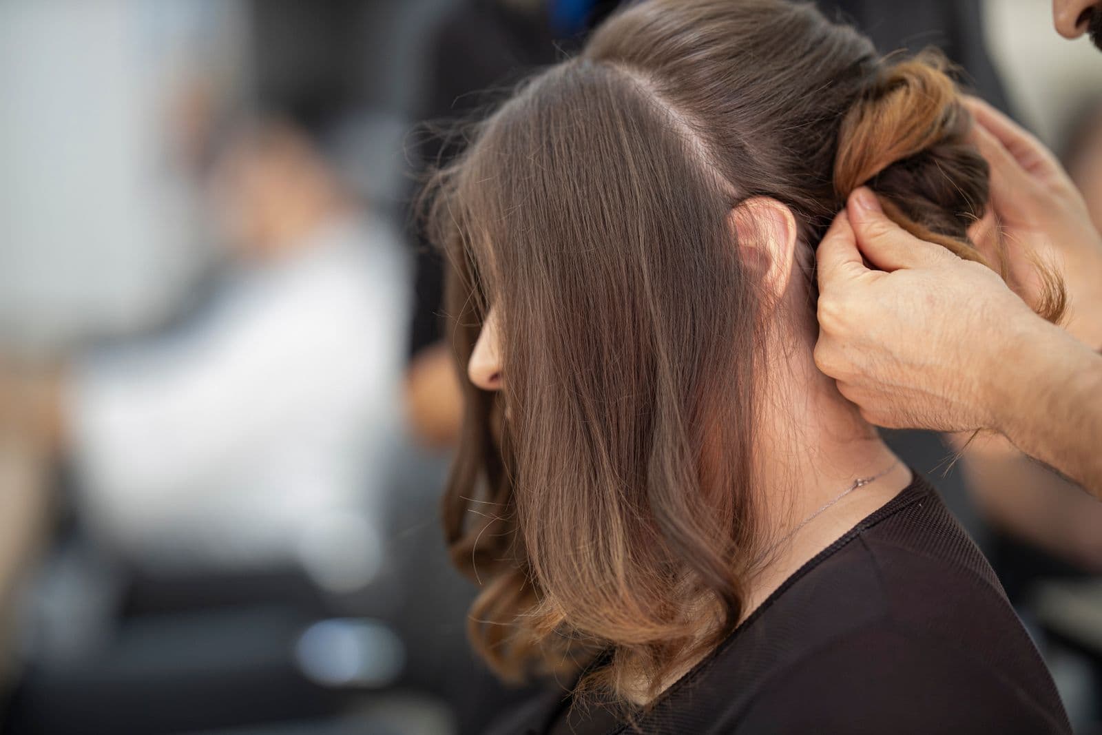 Hairdresser carefully styling and cutting a womans hair in a salon